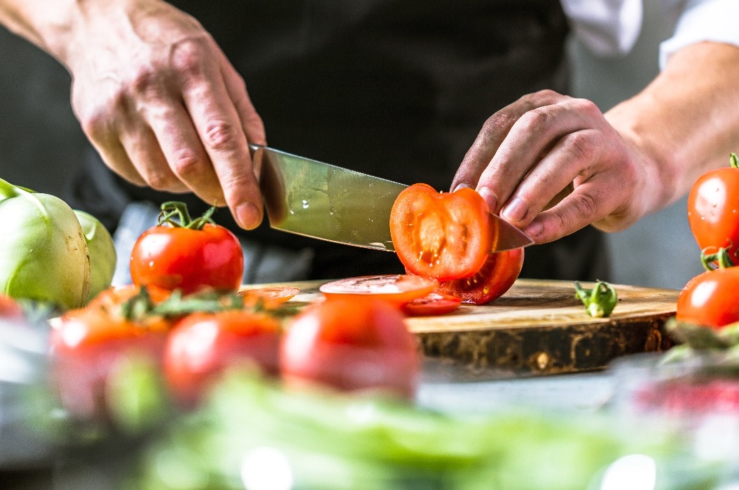Chefkoch in der Küche mit Frischem Gemüse(Tomaten)